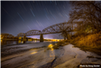 Railroad Bridge crossing the Missouri River in front of a starry night sky. 
