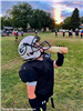 A boy wearing football pads drinks from a water bottle. 