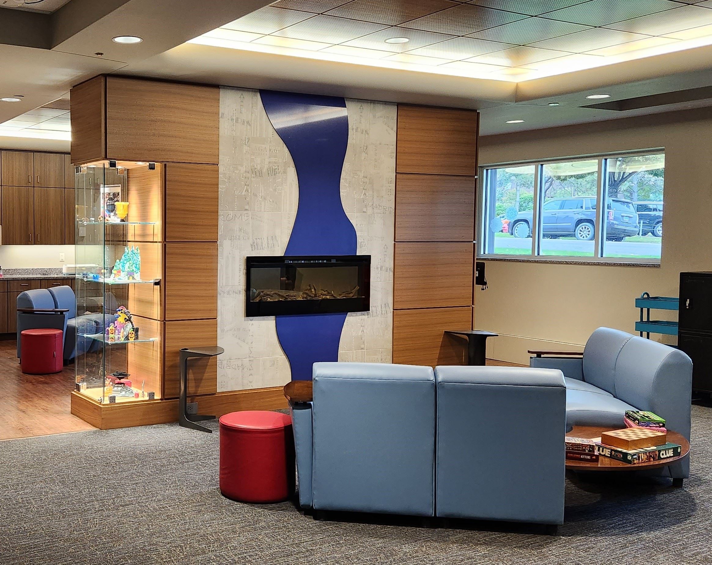 A room with blue couches in front of a fireplace