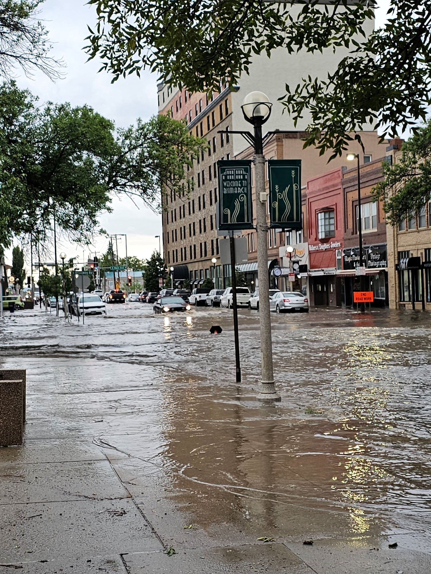 A vehicle drives through bumper-deep water in downtown Bismarck. 