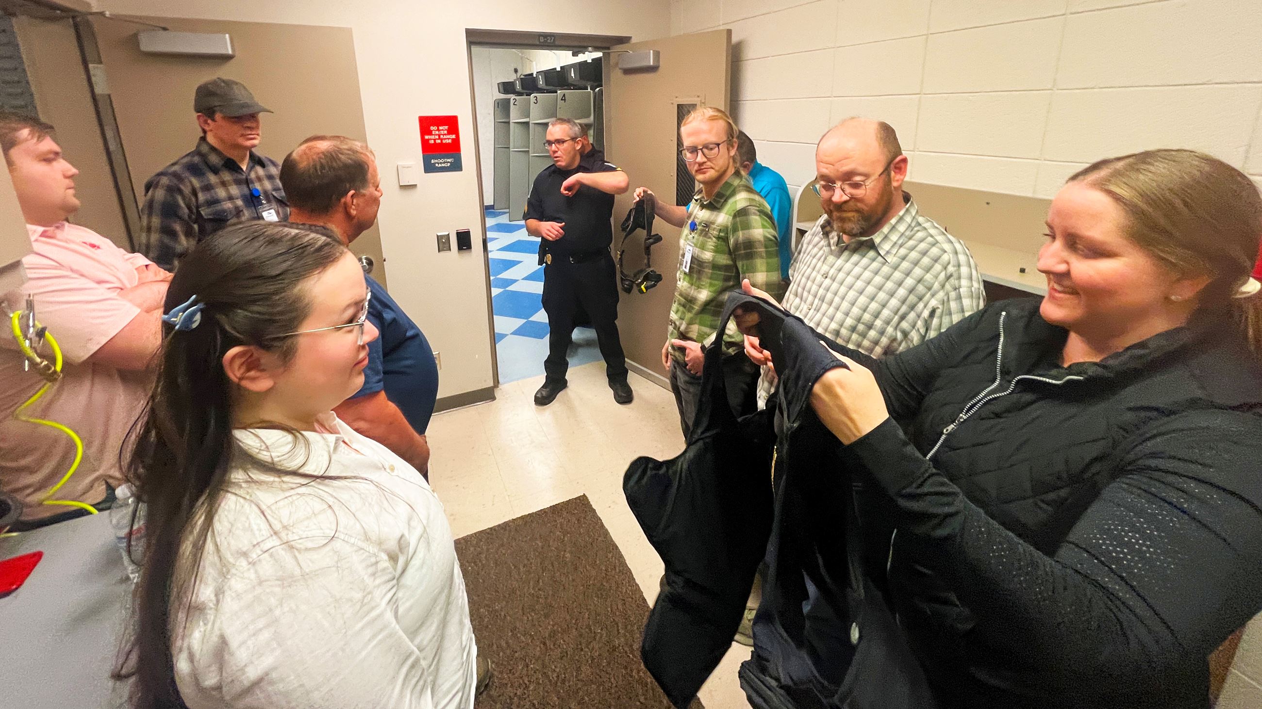 Citizen Academy attendees pass a kevlar vest amongst the group to see how much it weighs. 