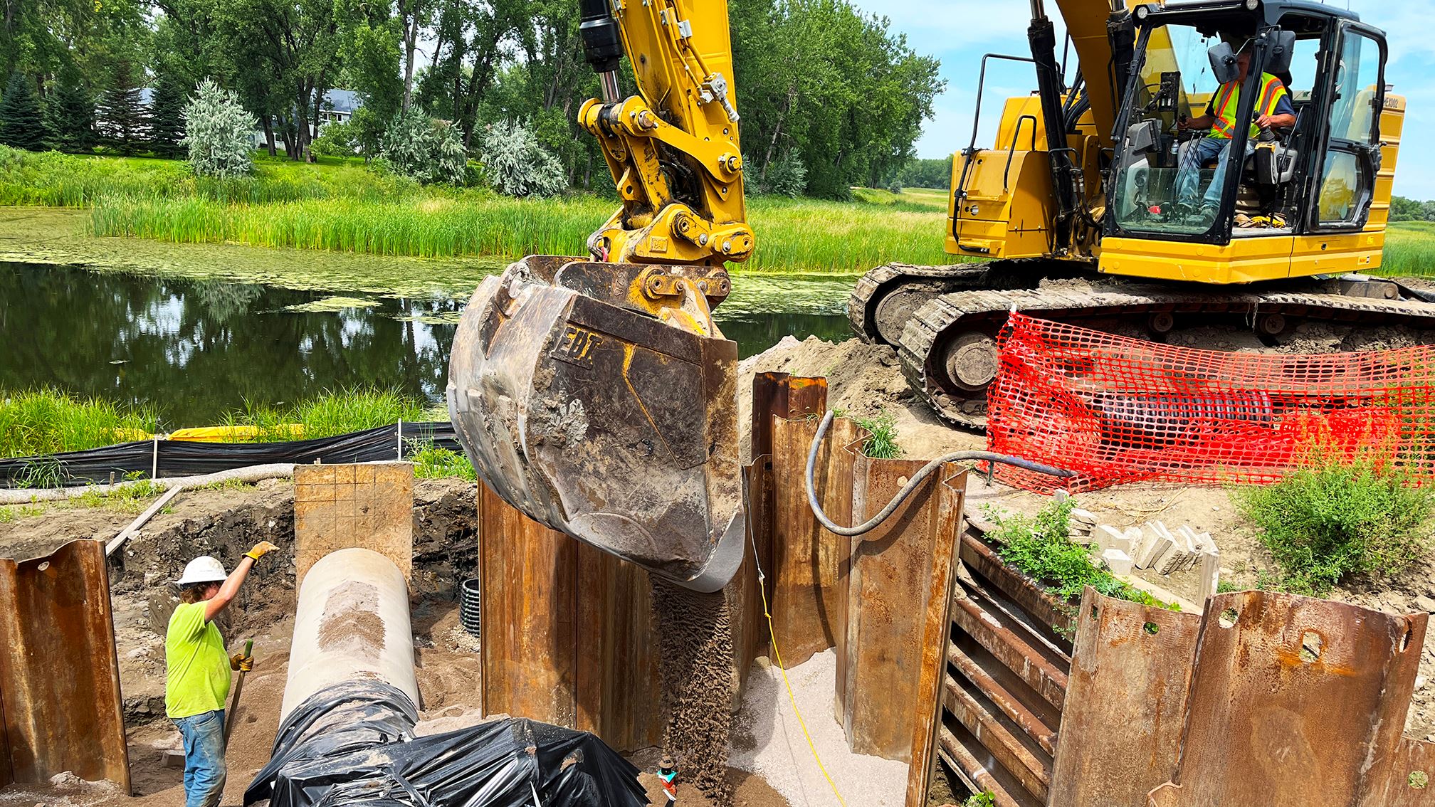 An excavator dumps sand into a construction area near Tavis Road. 