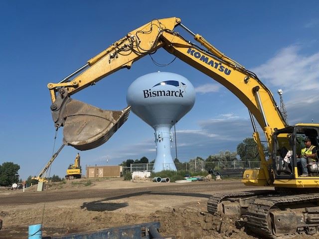Excavator with water tower in the background
